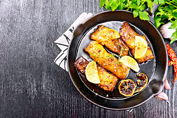 Image showing Salmon with sauce in pan on board top