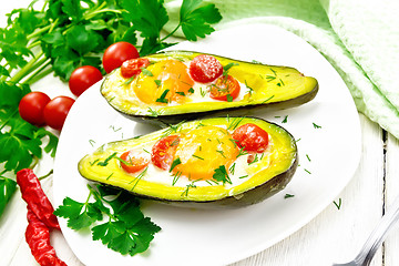 Image showing Scrambled eggs with tomatoes in avocado on light board