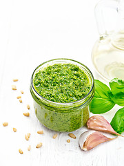 Image showing Pesto in glass jar on wooden board