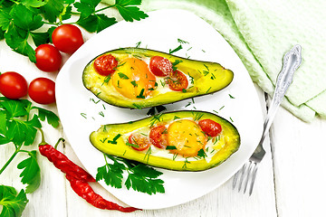 Image showing Scrambled eggs with tomatoes in avocado on board top