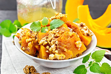 Image showing Pumpkin with nuts and honey on black board