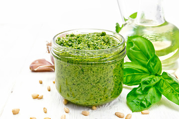 Image showing Pesto in glass jar on board
