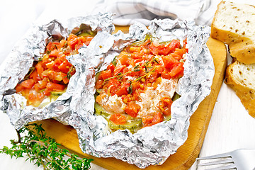 Image showing Salmon with vegetables in foil on light board