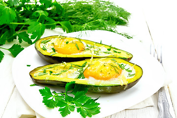 Image showing Scrambled eggs in avocado on light wooden board