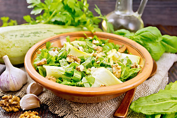 Image showing Salad with squash and sorrel in clay plate on dark board