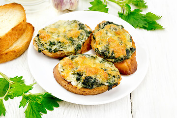 Image showing Sandwich of nettle and cheese in plate on wooden board