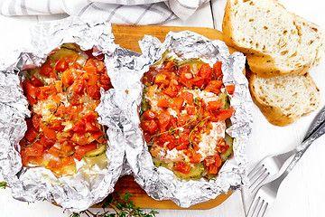 Image showing Salmon with vegetables in foil on board top