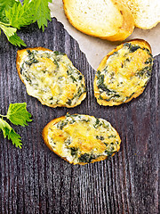 Image showing Sandwich of nettle and cheese on dark wooden board top