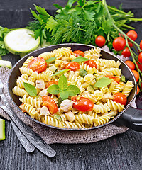 Image showing Fusilli with chicken and tomatoes in pan on burlap