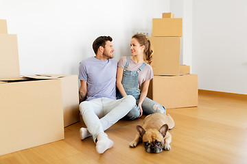 Image showing happy couple with boxes and dog moving to new home
