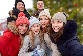 Image showing friends showing thumbs up over christmas tree