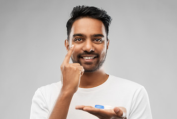 Image showing young indian man applying contact lenses