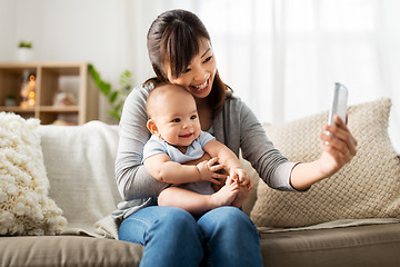 Image showing happy mother with baby son taking selfie at home