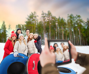 Image showing friends with snow tubes taking photo by tablet pc