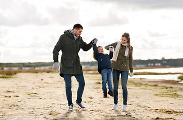 Image showing happy family walking along autumn beach