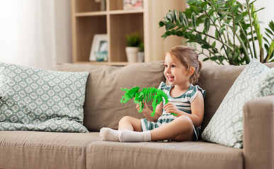 Image showing happy baby girl playing with toy dinosaur at home