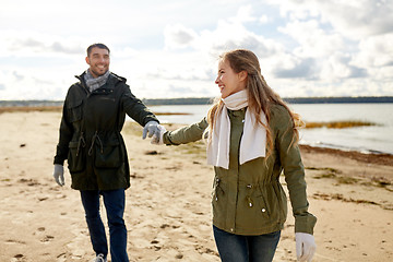 Image showing couple walking along autumn beach