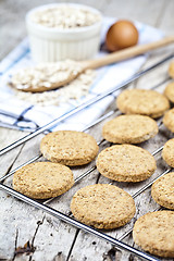 Image showing Baking grid with fresh oat cookies on rustic wooden table backgr