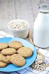 Image showing Fresh baked oat cookies on blue ceramic plate on linen napkin, b