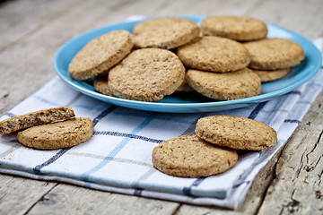 Image showing Fresh baked oat cookies on blue ceramic plate on linen napkin on