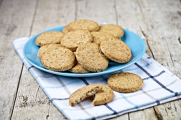 Image showing Fresh baked oat cookies on blue ceramic plate on linen napkin on