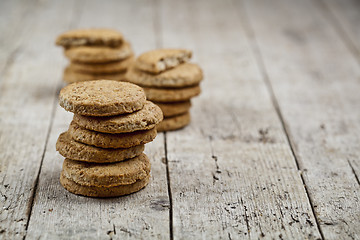 Image showing Stacks of fresh baked oat cookies on rustic wooden table backgro