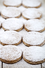 Image showing Fresh baked oat cookies with sugar powder closeup on rustic wood