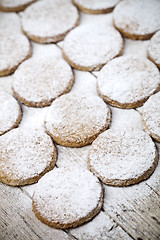 Image showing Fresh baked oat cookies with sugar powder on rustic wooden table