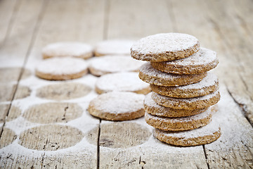 Image showing Fresh oat cookies with sugar powder closeup on rustic wooden tab