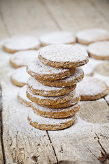 Image showing Fresh oat cookies with sugar powder closeup on rustic wooden tab