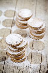 Image showing Fresh oat cookies stacks with sugar powder on rustic wooden tabl