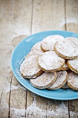 Image showing Fresh baked oat cookies with sugar powderon blue ceramic plate c