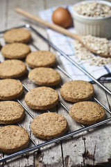 Image showing Baking grid with fresh oat cookies on rustic wooden table backgr