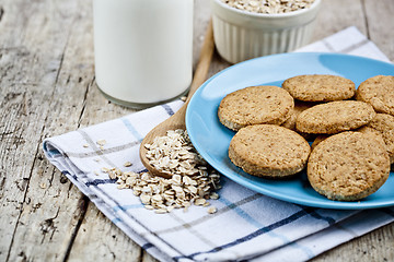 Image showing Fresh baked oat cookies on blue ceramic plate on linen napkin, b