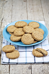 Image showing Fresh baked oat cookies on blue ceramic plate on linen napkin on