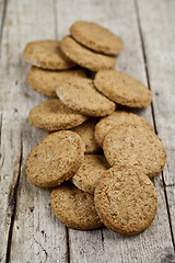 Image showing Fresh baked homemade oat cookies on rustic wooden table.