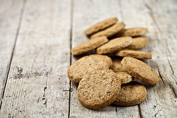 Image showing Fresh baked oat cookies heap on rustic wooden table background.