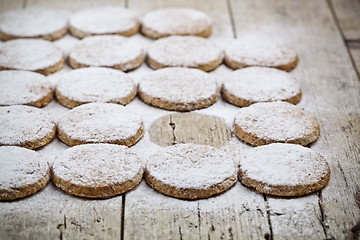 Image showing Fresh baked oat cookies with sugar powder on rustic wooden table