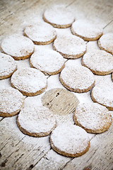 Image showing Fresh baked oat cookies with sugar powder on rustic wooden table