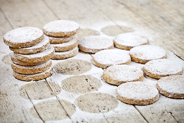 Image showing Fresh baked oat cookies with sugar powder on rustic wooden table