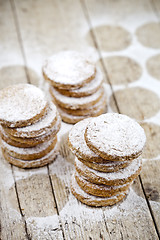 Image showing Fresh oat cookies stacks with sugar powder on rustic wooden tabl