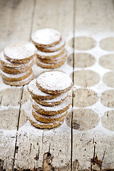 Image showing Fresh baked oat cookies with sugar powder on rustic wooden table