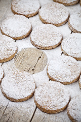 Image showing Fresh baked oat cookies with sugar powder on rustic wooden table
