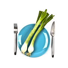Image showing Organic green onion on blue plate, fork and knife on white backg
