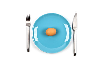 Image showing Fresh chicken boiled egg on blue plate, fork and knife on white 