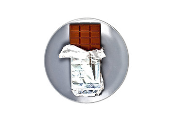 Image showing Chocolate bar with foil on grey ceramic plate isolated on white 