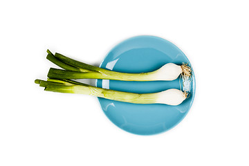 Image showing Organic green onion on blue plate on white background. 