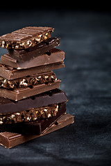 Image showing Chocolate bar pieces closeup. Sweet food photo concept.