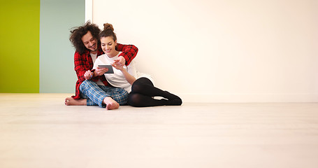 Image showing Young Couple using digital tablet on the floor