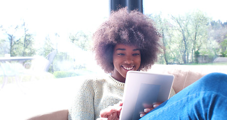 Image showing african american woman at home using digital tablet